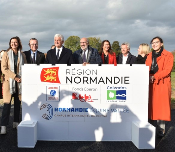 Les élus de Normandie Equine Vallée posent devant le mur qu'ils viennent de construire dans le cadre de la pose de la 1ère pierre du Campus international du cheval à Goustranville