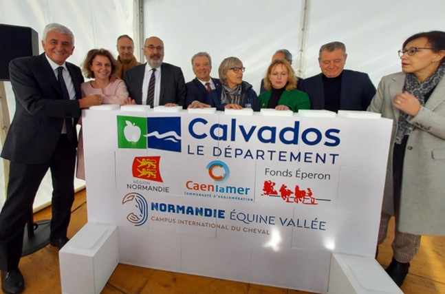 Les élus de Normandie Equine Vallée posent devant le mur qu'ils viennent de construire dans le cadre de la pose de la 1ère pierre du Campus international du cheval à Saint-Contest